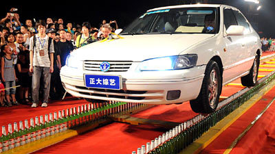7793_src Китаец установил рекорд, проехав на автомобиле по двум рядам стеклянных бутылок